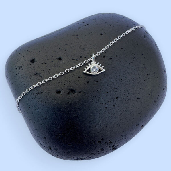 Silver anklet with an evil eye charm with white gemstone in the centre.