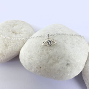 Silver anklet with an evil eye charm with white gemstone in the centre.