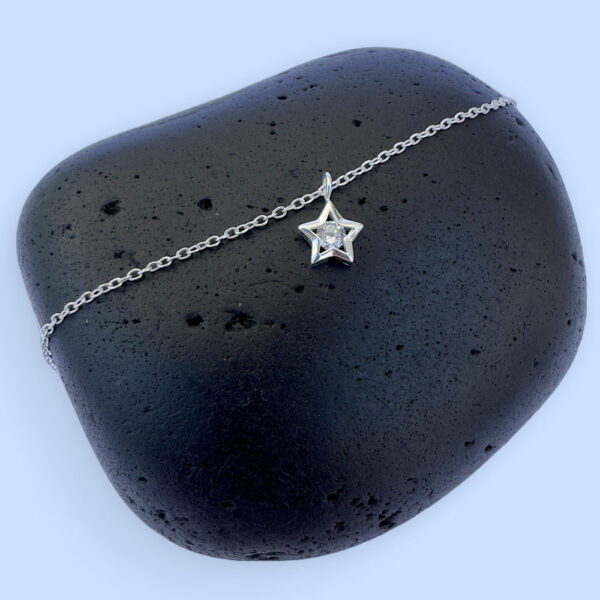 Celestial ankle bracelet with a star charm with a white gemstone in the centre.