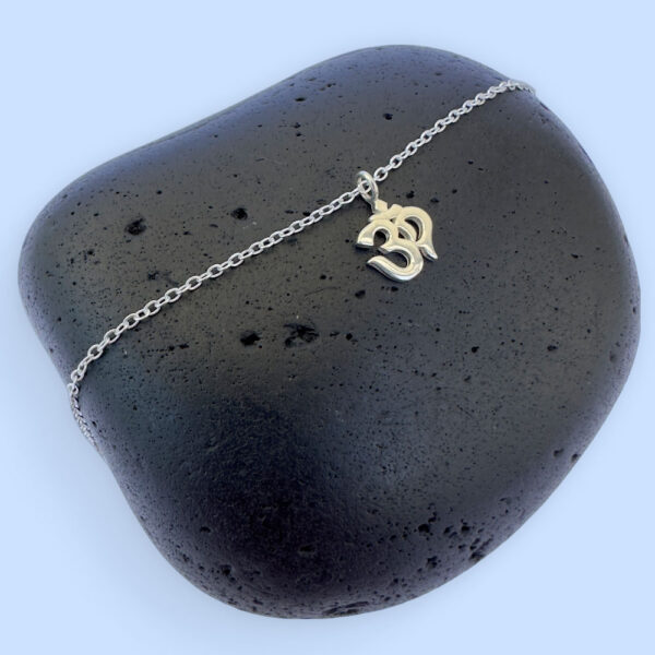 Spiritual anklet with a silver ohm symbol charm.