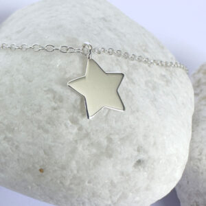 Close up of shiny bright anklet with solid silver star charm.