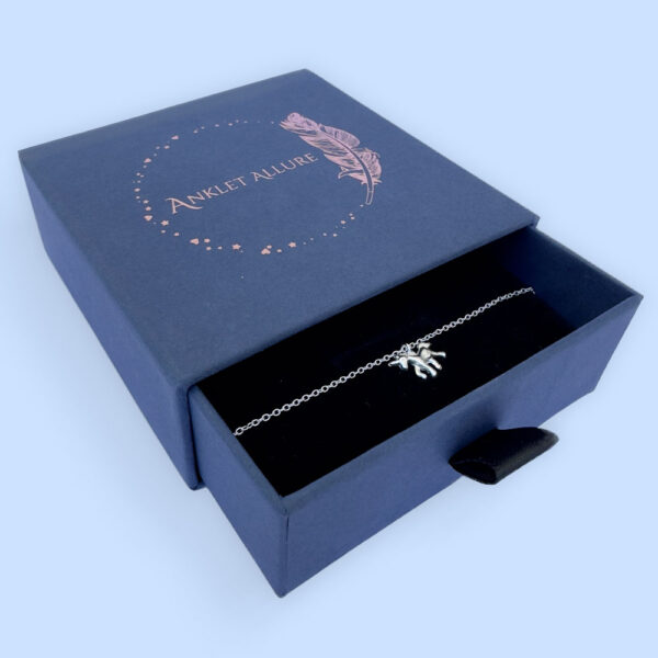 Anklet with a cute unicorn charm, perfect for a little girl, presented in a blue jewellery box with Anklet Allure written on the top in rose gold.