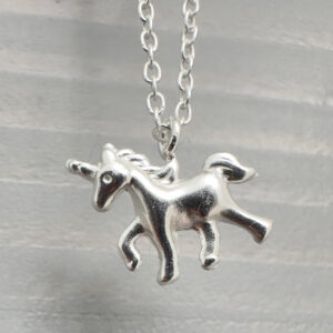 Close up of sterling silver anklet with unicorn charm.