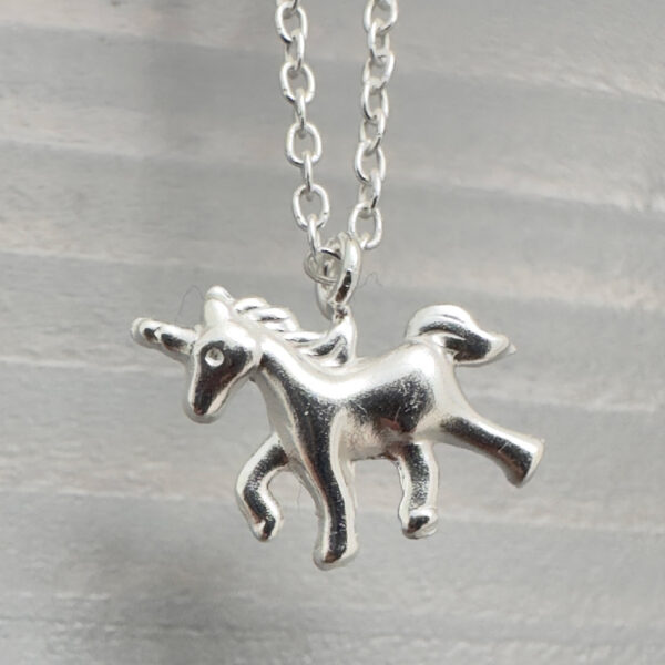 Close up of sterling silver anklet with unicorn charm.