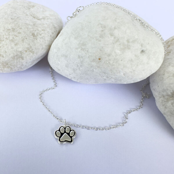 Silver anklet with a charm of a pawprint with ionised silver detail.