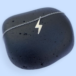 Powerful silver anklet with a charm of a lightening bolt.