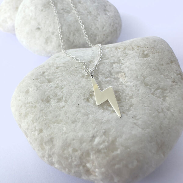 Powerful energy silver anklet with a charm of a lightening bolt.