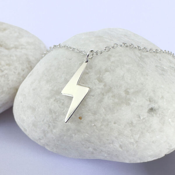 Powerful silver anklet with a charm of a lightening bolt.