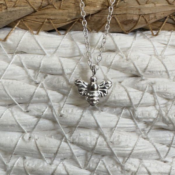 Sterling silver bee charm on a silver ankle bracelet.