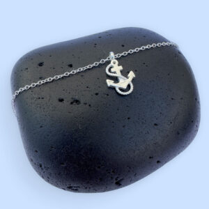 Silver anklet with a charm of an anchor with a rope wrapped around it in an s shape.