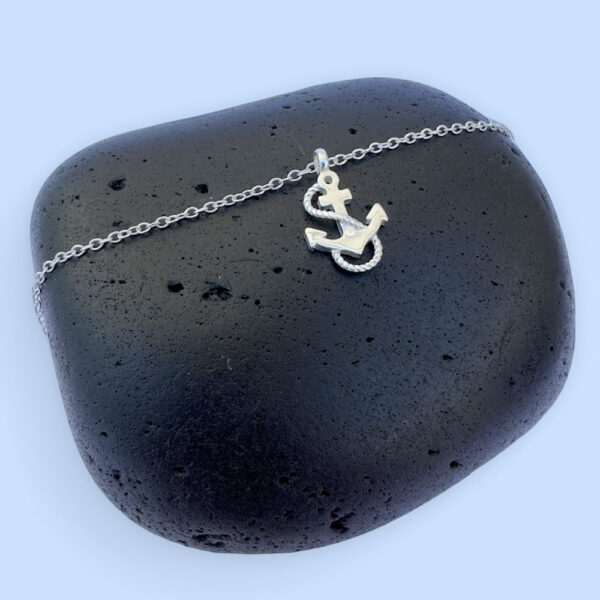 Silver anklet with a charm of an anchor with a rope wrapped around it in an s shape.