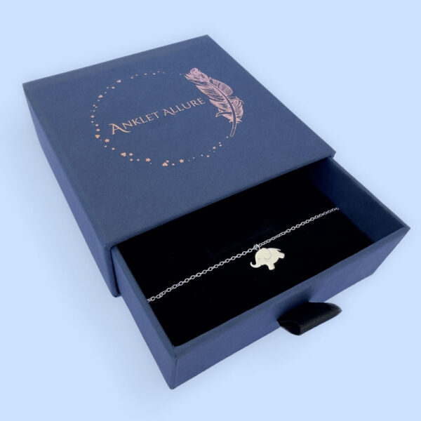 Children's anklet with cute solid silver elephant charm. presented in a blue jewellery box with Anklet Allure written on the top in rose gold.