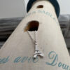 Eiffel Tower charm on a silver ankle bracelet laying on a lighthouse decoration.