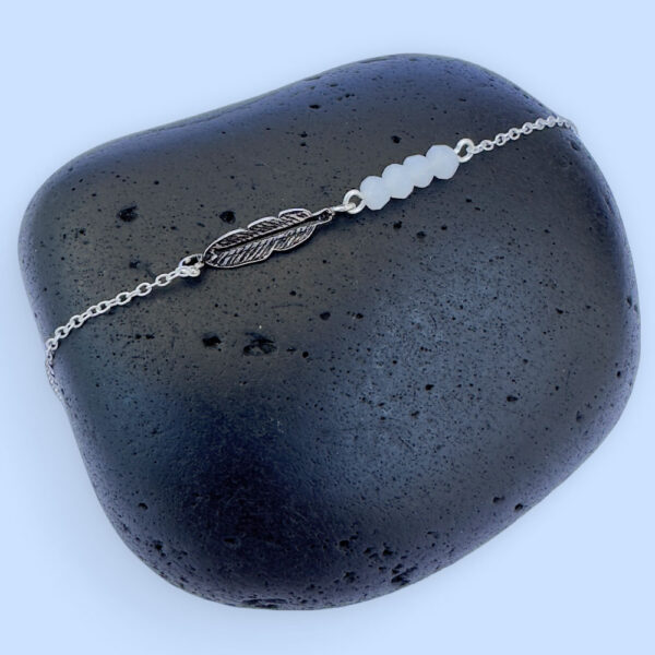 Sterling silver dainty anklet with an iodised silver style feather charm and four white beads.