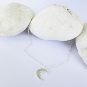 Feminine silver anklet with a crescent moon charm.