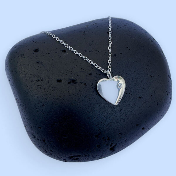 Sterling silver anklet with a large flat heart charm with a white gemstone.
