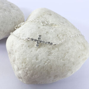 A dainty sterling silver anklet with a stunning gem encrusted cross within the chain.