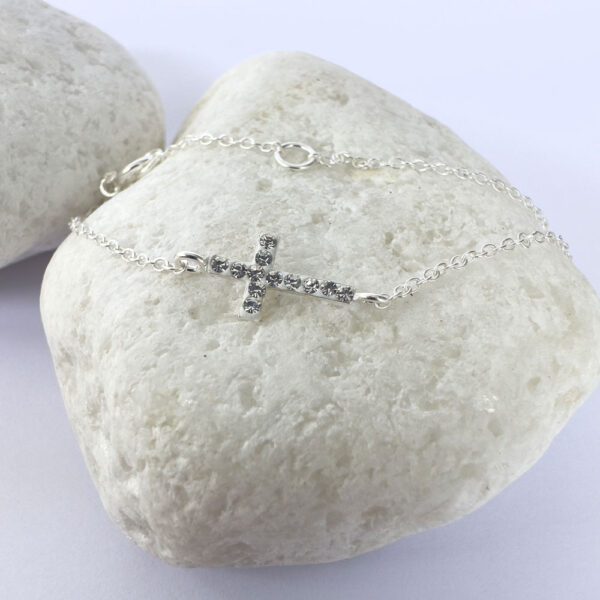 A dainty sterling silver anklet with a stunning gem encrusted cross within the chain.
