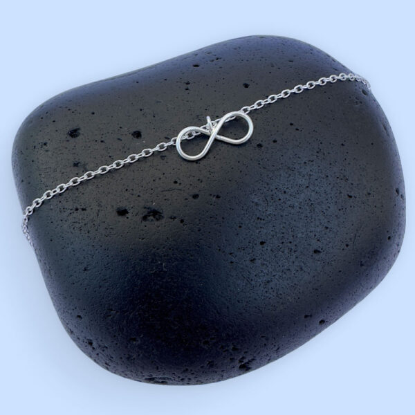 Silver ankle bracelet with a dainty infinity charm.