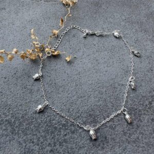 Sterling silver anklet with seven small tulip flower shaped charms in equal distance around the ankle chain.