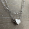 Simple sterling silver heart charm on a plain silver anklet.