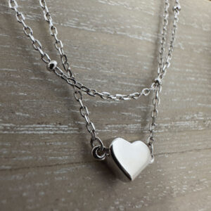 Simple sterling silver heart charm on a plain silver anklet.