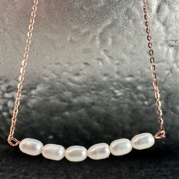 Six oval shaped beautiful freshwater pearls sitting close together on a stunning rose gold ankle chain.