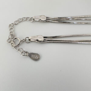 Close up of triple chain silver anklet with 925 sterling silver stamp.