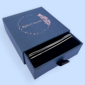 Triple chain silver anklet in a blue jewellery box.