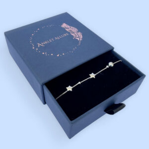 Silver anklet with solid star and ball charms in a blue Anklet Allure jewellery box.