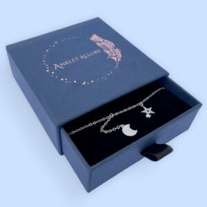 Ankle bracelet with a five pointed star and a crescent moon, both diamond encrusted, presented in a blue box.