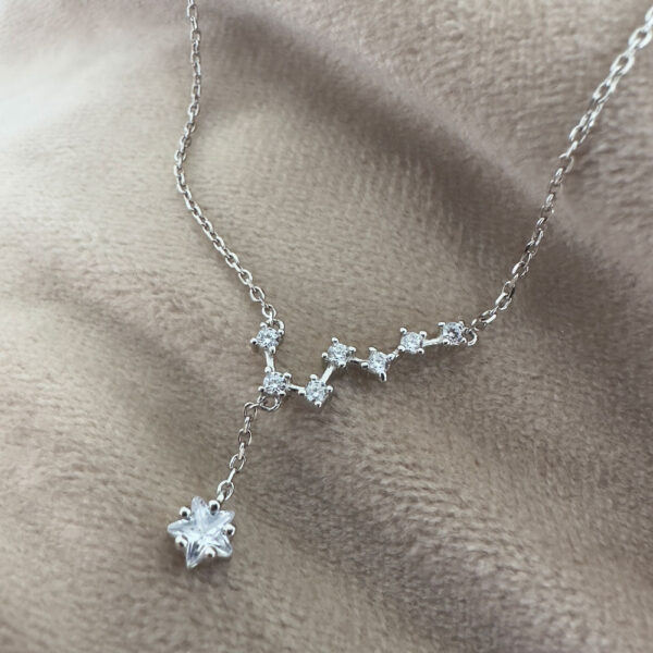 Seven smaller cubic zirconia gems linked together in a pattern similar to the big dipper star formation, with a larger gemstone as the main feature hanging lower from the silver ankle bracelet.