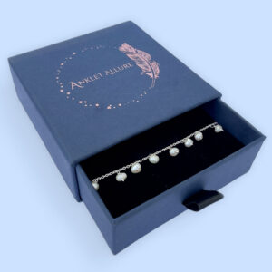 Amazing anklet with freshwater pearls hanging all the way around, presented in a blue jewellery box with Anklet Allure written on the top in rose gold.