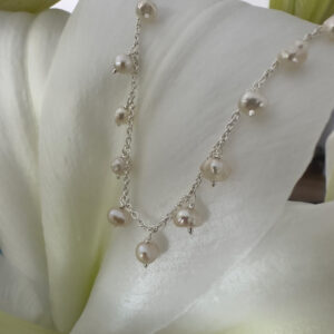 Elegant freshwater pearls at equal distance apart, around a shiny sterling silver ankle chain.
