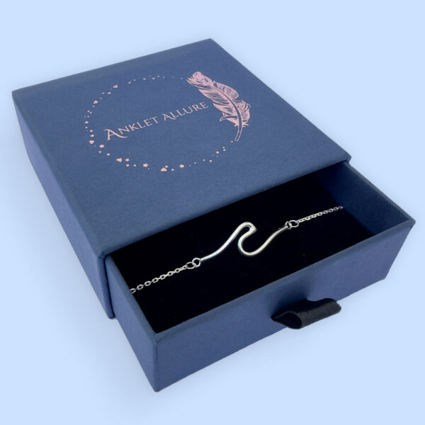 Sterling silver anklet with a surf wave design in a dark blue Anklet Allure jewellery box.