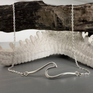 Beach Chic anklet of a shiny silver rolling wave draped over some driftwood.