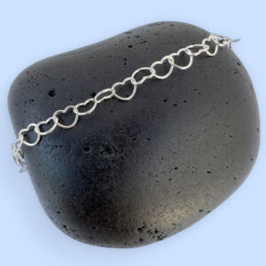 Silver anklet made of identical linked delicate silver hearts.