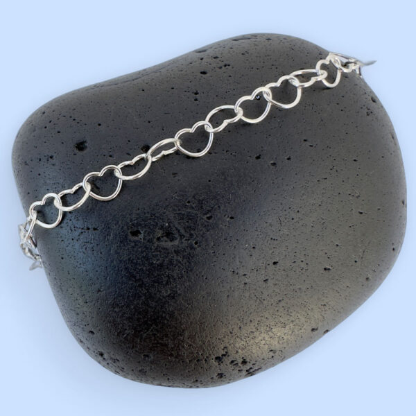 Silver anklet made of identical linked delicate silver hearts.