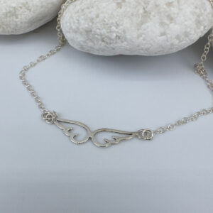 Feminine silver anklet with an angel's wings sitting in the chain.