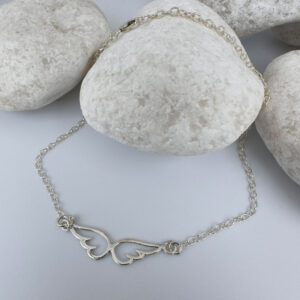 Eye catching silver anklet with an angel's wings sitting in the chain.