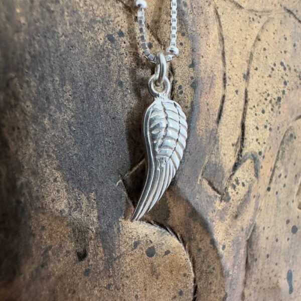 A meaningful silver single angel wing charm on a 925 sterling silver anklet.