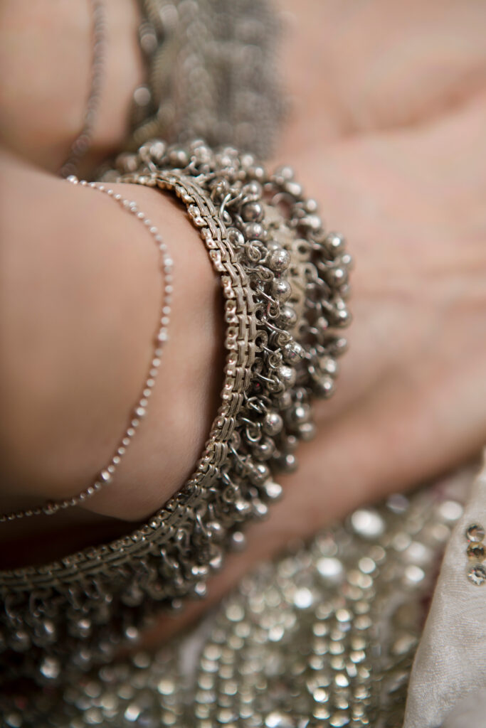 Close up of ankle wearing jingling gold anklets.